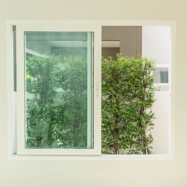 Une fenêtre avec une haie verte en arrière-plan, mettant en valeur l'installation.